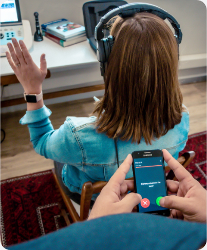 Audiologist conducting smartphone hearing screening on female