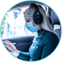 Low-touch, curb-side hearing assessment conducted by female